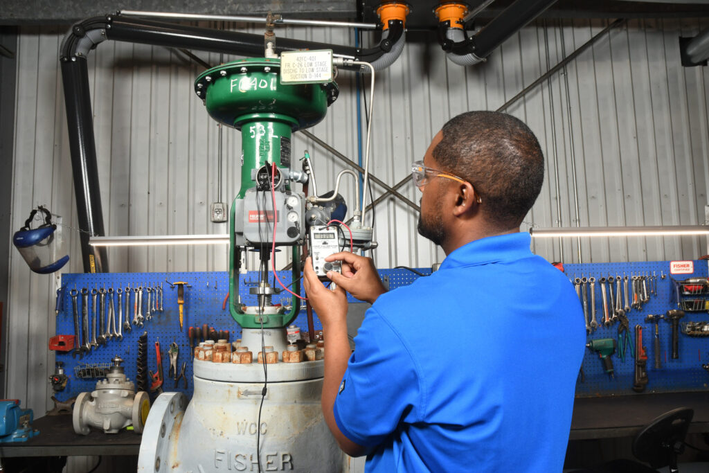 Technician calibrating a control valve positioner on the bench